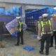 Foto : Personel Satlantas Polres Pamekasan memasang spanduk imbauan kepada sopir truk angkutan garam di area Gudang Garam, Desa Majungan, Kecamatan Pademawu, Kabupaten Pamekasan, Kamis (27/8/2026). Imbauan terkait penutupan muatan dengan terpal untuk mengantisipasi jalan licin akibat tetesan air garam.